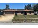 Charming single-story brick home featuring an attached garage and solar panels on the roof at 974 Feather Dr, Deltona, FL 32725