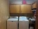 Cozy laundry room offering storage cabinets, washer, dryer, and utility sink at 974 Feather Dr, Deltona, FL 32725