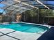 View of an outdoor swimming pool with screened enclosure and lounge chairs at 974 Feather Dr, Deltona, FL 32725