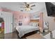 Charming bedroom with pink walls, a ceiling fan and a queen-size bed at 1001 11Th St, St Cloud, FL 34769