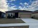 Single-story house with a two-car garage and landscaping at 1075 Aerides Way, Davenport, FL 33837