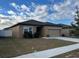 Tan house with a two-car garage and white fence at 1075 Aerides Way, Davenport, FL 33837
