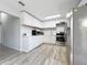 Modern kitchen featuring white cabinets, stainless steel appliances, and wood-look flooring at 1109 5Th Sw St, Winter Haven, FL 33880
