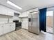Updated kitchen with white cabinets, stainless steel appliances, and access to a patio at 1109 5Th Sw St, Winter Haven, FL 33880