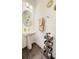Elegant half bathroom features a pedestal sink, round mirror, updated lighting and decorative accents at 15079 Willow Arbor Cir, Orlando, FL 32824