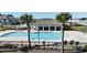 Community pool surrounded by palm trees, lounge chairs, and a covered pergola overlooking other buildings at 15079 Willow Arbor Cir, Orlando, FL 32824