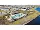 Aerial view of a community pool featuring a pergola, palm trees, a playground and a lakeside location at 15079 Willow Arbor Cir, Orlando, FL 32824