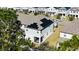 Back exterior of a two story home featuring a large solar panel system, a screened in patio and manicured lawn at 15079 Willow Arbor Cir, Orlando, FL 32824