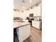 Modern kitchen featuring stainless appliances, tiled backsplash, white cabinetry and an island with breakfast bar at 15079 Willow Arbor Cir, Orlando, FL 32824