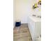 Tiled laundry room featuring a white washer and dryer set and convenient shelving for storage of cleaning supplies at 15079 Willow Arbor Cir, Orlando, FL 32824