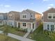 Two-story house with gray and beige siding, stone accents, and a front porch at 16567 Parable Way, Winter Garden, FL 34787