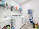 Bright laundry room with washer, dryer, and ample shelving at 17863 Passionflower Cir, Clermont, FL 34714