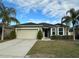 One-story house with a two-car garage and landscaped lawn at 180 Daigledog St, St Cloud, FL 34772