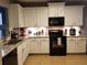 Modern kitchen with white cabinets and black appliances at 180 Daigledog St, St Cloud, FL 34772