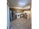 Well-lit kitchen featuring stainless steel refrigerator, range, and ample cabinet space at 1919 Bentley Blvd, Kissimmee, FL 34741