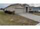 A charming house with a gray exterior, a two-car garage, and a neat front yard at 231 Tarpon Bay Blvd, Haines City, FL 33844