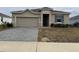Newly constructed home with a two-car garage and well-manicured lawn at 231 Tarpon Bay Blvd, Haines City, FL 33844