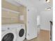 Upstairs laundry area with washer, dryer, shelving, and easy access from the hallway at 2617 Amati Dr, Kissimmee, FL 34741