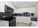 Modern kitchen with white cabinets, stainless steel appliances, and dark gray tile backsplash at 3131 Paradox Cir # 401, Kissimmee, FL 34746