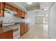 Open kitchen with tile flooring, a bright stove and abundant wood cabinets at 33 W Country Cove Way, Kissimmee, FL 34743