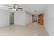Open concept living area with tile flooring, ceiling fan, and access to kitchen with wood cabinetry at 33 W Country Cove Way, Kissimmee, FL 34743