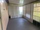 Enclosed sunroom featuring painted concrete floor, white blinds, and access to the exterior at 33 W Country Cove Way, Kissimmee, FL 34743