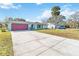 House with a red garage door and palm tree at 508 Bar Dr, Kissimmee, FL 34759