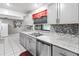 Gray cabinets, granite countertops, and stainless steel appliances at 508 Bar Dr, Kissimmee, FL 34759