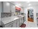 Modern kitchen with gray cabinets, granite countertops, and tile backsplash at 508 Bar Dr, Kissimmee, FL 34759