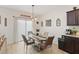 Bright dining room with a glass-top table and four chairs, near sliding door at 592 Madison Dr, Davenport, FL 33837
