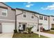 Two-story townhome with gray and beige siding and a two-car garage at 592 Madison Dr, Davenport, FL 33837