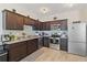 Modern kitchen with dark wood cabinets, stainless steel appliances and granite countertops at 592 Madison Dr, Davenport, FL 33837