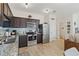 Modern kitchen with dark wood cabinets, stainless steel appliances and granite countertops at 592 Madison Dr, Davenport, FL 33837