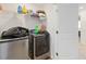 Bright laundry room with washer and dryer, and ample shelving at 592 Madison Dr, Davenport, FL 33837
