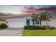 One-story home with white exterior, blue accents, and a paved driveway at 6308 Chirpine Ln, St Cloud, FL 34771
