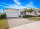 Front view of a single-story house with a white exterior and palm trees at 6308 Chirpine Ln, St Cloud, FL 34771