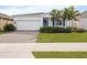 White one-story house with a two-car garage and landscaped lawn at 6308 Chirpine Ln, St Cloud, FL 34771