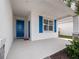 Covered porch with blue door and shutters, offering a welcoming entryway at 6308 Chirpine Ln, St Cloud, FL 34771