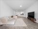 Bright living room with tile floors, large sectional sofa, and modern TV stand at 6308 Chirpine Ln, St Cloud, FL 34771