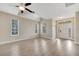 Bright living room featuring new gray flooring, ceiling fan, and a front door entrance at 6921 Cupseed Ln, Harmony, FL 34773