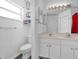 Bright bathroom with a double sink vanity, white cabinets, and a window for natural light at 760 Lake Marion Golf Resort, Poinciana, FL 34759