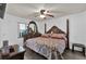 Main bedroom with a large wooden bed, matching furniture, ceiling fan, and neutral wall colors at 760 Lake Marion Golf Resort, Poinciana, FL 34759
