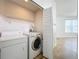 Laundry closet with washer and dryer, shelving and louvered doors at 8079 Cloverglen Cir, Orlando, FL 32818