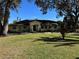 Beautiful yellow house with a large green lawn and mature trees at 825 E Lakeshore Blvd, Kissimmee, FL 34744