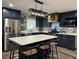 Modern kitchen boasts dark cabinetry, quartz countertops, and a large island with seating at 825 E Lakeshore Blvd, Kissimmee, FL 34744