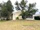 Back view of the house, showcasing the screened porch and landscaping at 1005 Tequesta Trl, Lake Wales, FL 33898