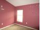 Simple bedroom with a window and pink walls at 1005 Tequesta Trl, Lake Wales, FL 33898