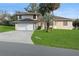 Two-story house with a spacious yard, attached garage, and palm trees at 10420 Vista Del Sol Cir, Clermont, FL 34711
