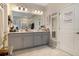 Double vanity bathroom with modern gray cabinets and a large mirror at 11120 Robert Frost Dr, Winter Garden, FL 34787