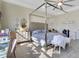 Main bedroom with a canopy bed, dresser, and sitting area at 11120 Robert Frost Dr, Winter Garden, FL 34787
